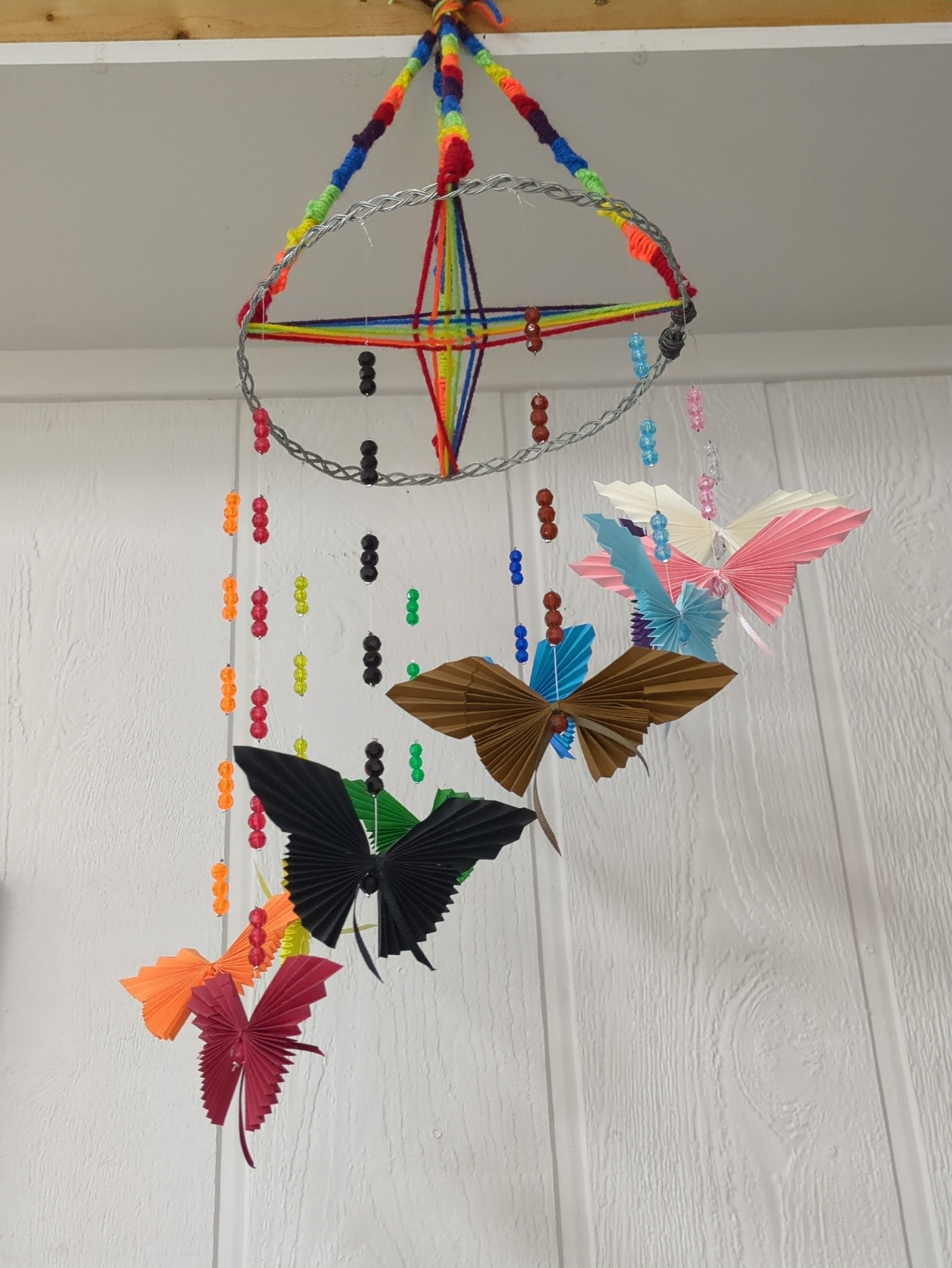 Hanging 3-D art of colorful beads and paper butterflies