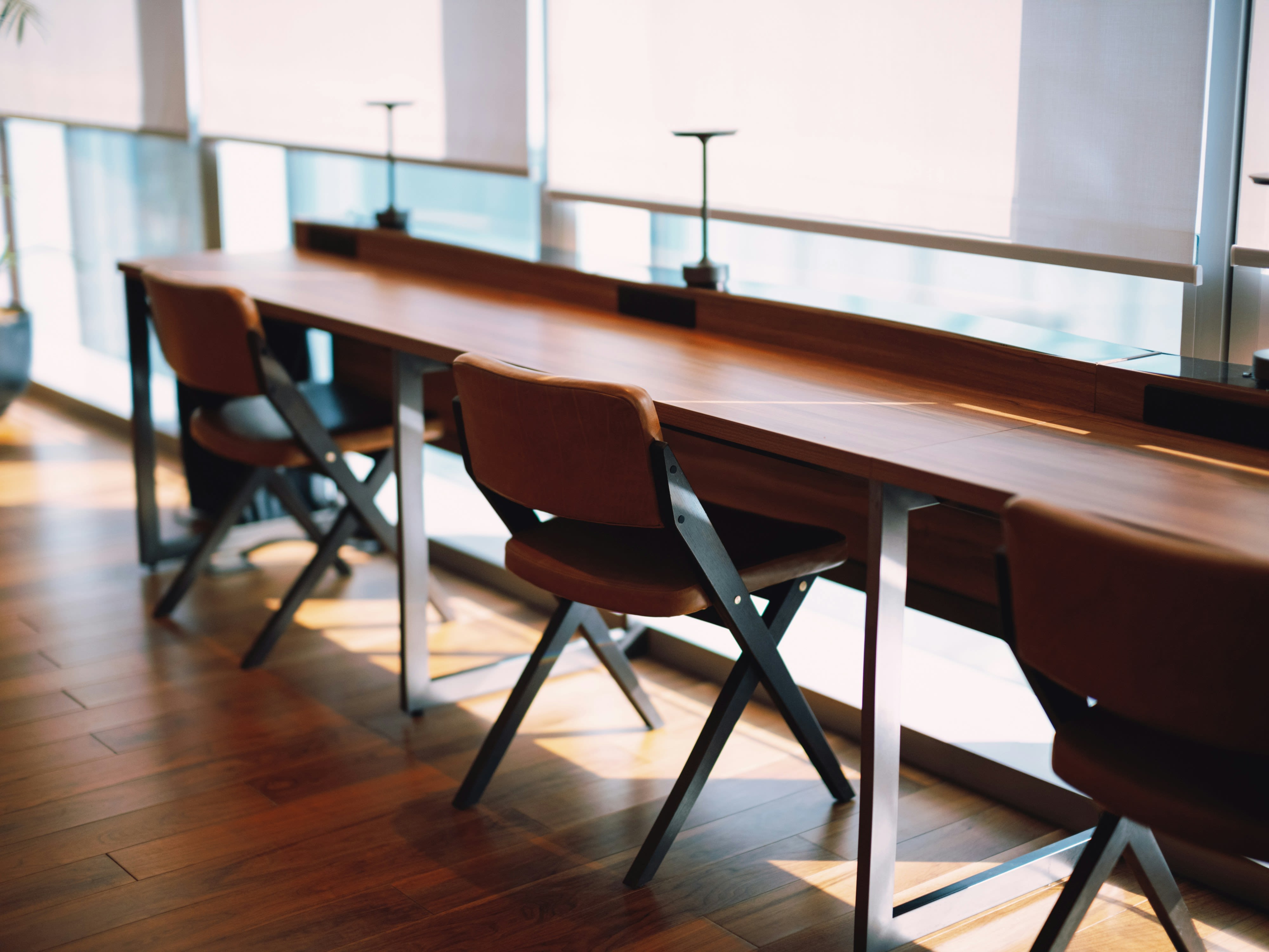 A long table with chairs in front of a window